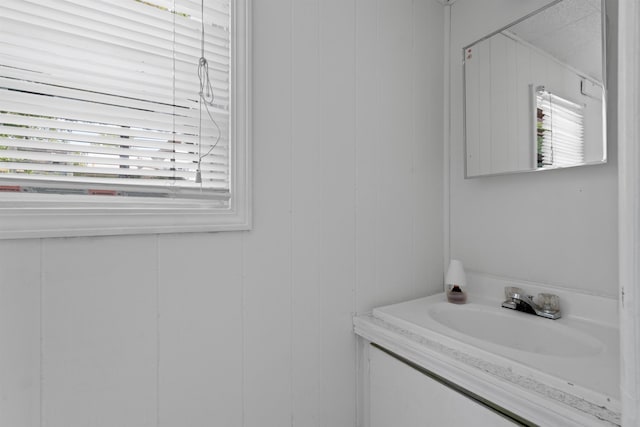 bathroom featuring vanity and wood walls