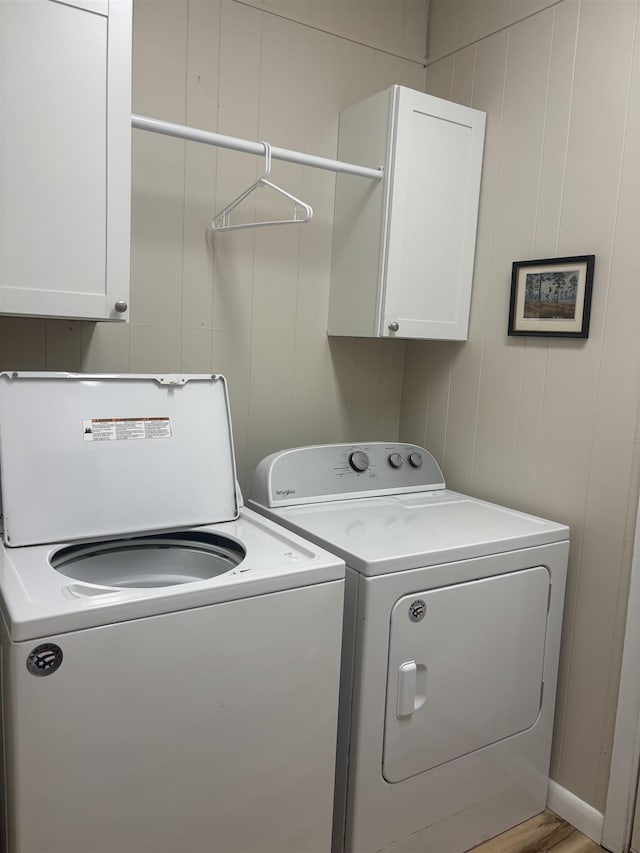 washroom featuring cabinets and washing machine and clothes dryer