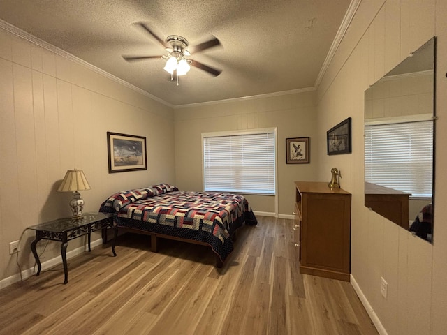 bedroom with ceiling fan, a textured ceiling, ornamental molding, and hardwood / wood-style floors