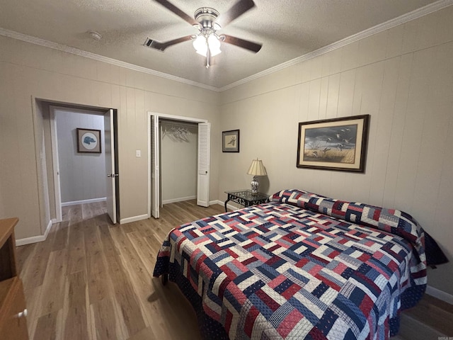 bedroom with ceiling fan, light hardwood / wood-style flooring, a textured ceiling, and ornamental molding