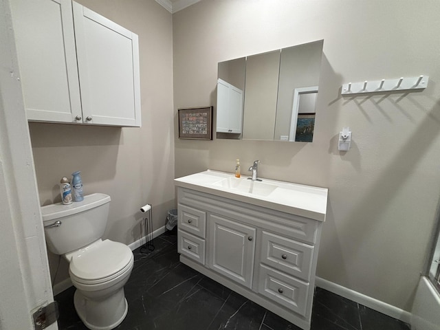 bathroom featuring toilet, crown molding, and vanity