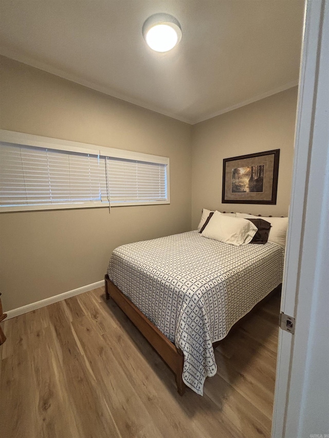 bedroom featuring hardwood / wood-style floors and ornamental molding