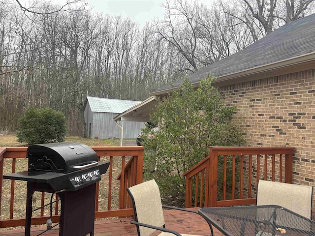 deck featuring a storage unit and a grill