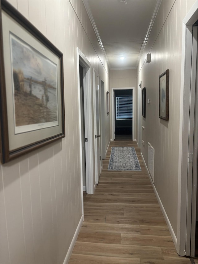 hallway featuring light wood-type flooring and crown molding