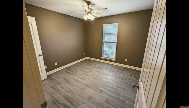 empty room featuring ceiling fan and dark hardwood / wood-style flooring