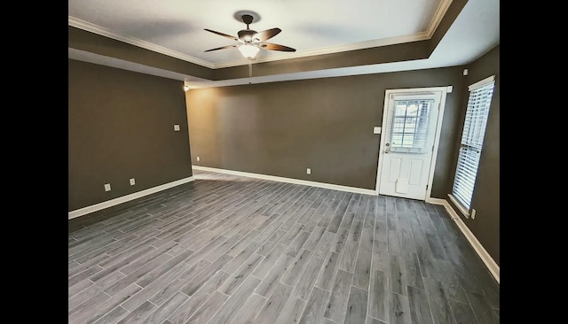 unfurnished room with ceiling fan, dark wood-type flooring, ornamental molding, and a raised ceiling