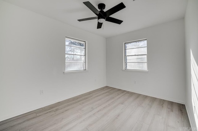 empty room with ceiling fan and light hardwood / wood-style floors