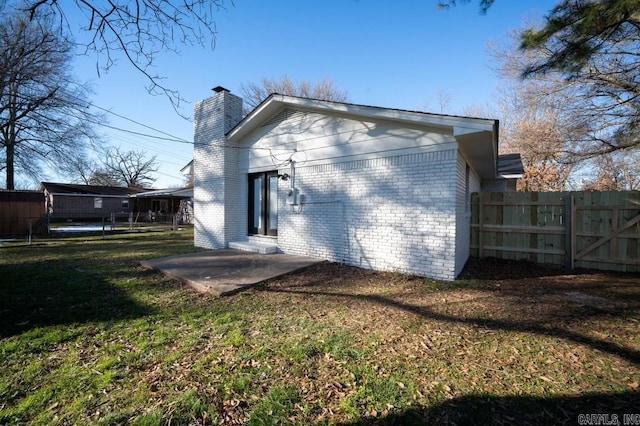 rear view of house featuring a lawn and a patio area