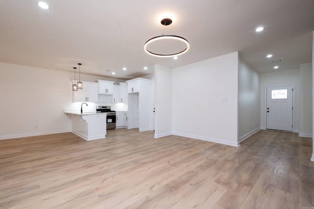 unfurnished living room featuring light hardwood / wood-style flooring and sink