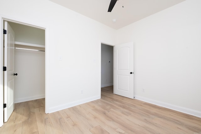 unfurnished bedroom with ceiling fan, a closet, and light wood-type flooring