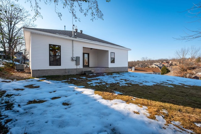 snow covered property with central air condition unit