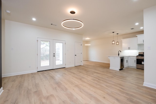 interior space with light hardwood / wood-style floors, french doors, and sink