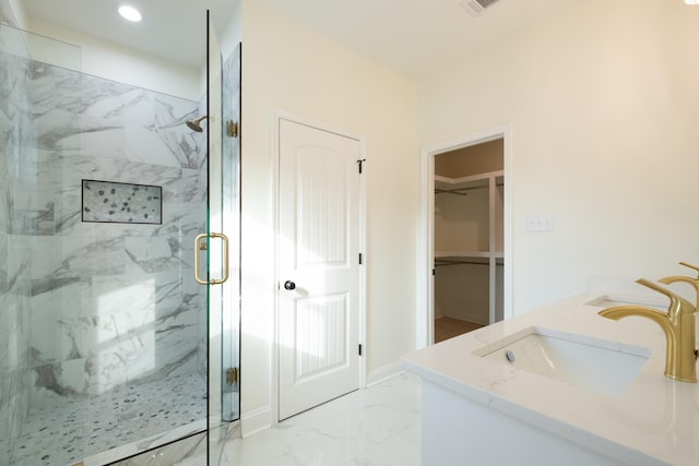 bathroom featuring a shower with door and vanity