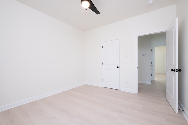 unfurnished bedroom featuring ceiling fan, light hardwood / wood-style flooring, and a closet