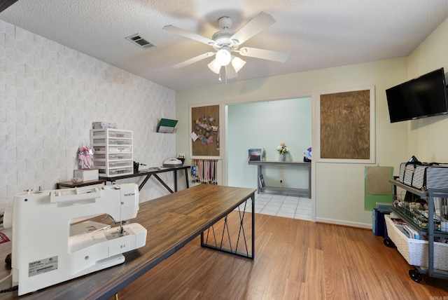 home office featuring a textured ceiling, ceiling fan, and hardwood / wood-style floors