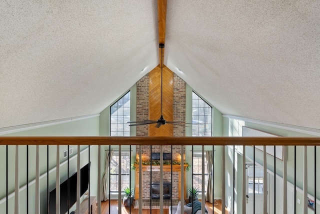 interior details with a textured ceiling, a brick fireplace, hardwood / wood-style flooring, and ceiling fan