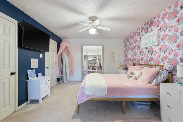 bedroom with a textured ceiling, ceiling fan, and light carpet