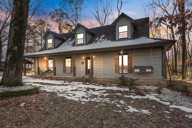 cape cod-style house featuring covered porch