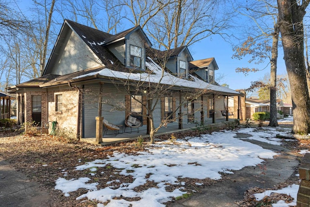 view of snowy exterior featuring a porch