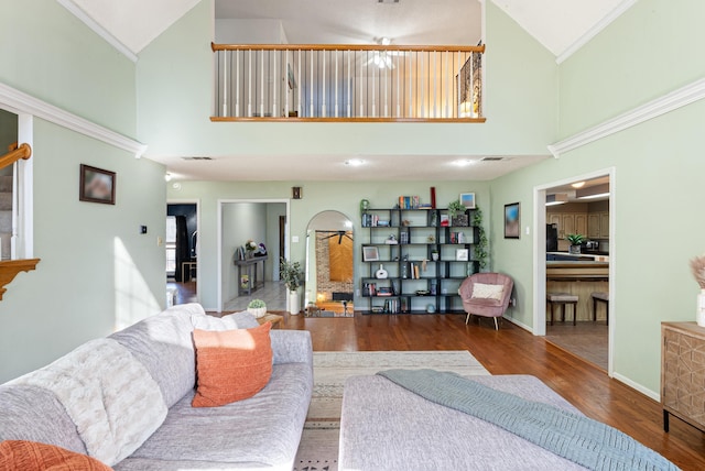 living room featuring crown molding, hardwood / wood-style flooring, and high vaulted ceiling