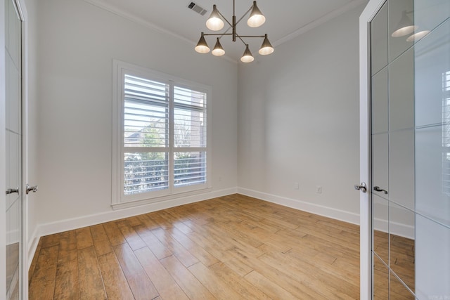 spare room featuring light wood-type flooring and crown molding