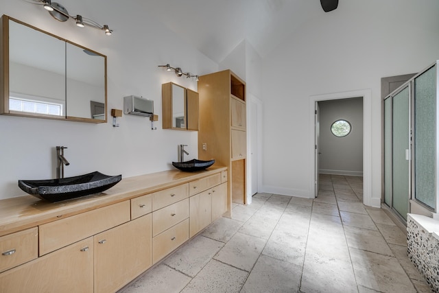 bathroom with a shower with shower door, a healthy amount of sunlight, and vanity