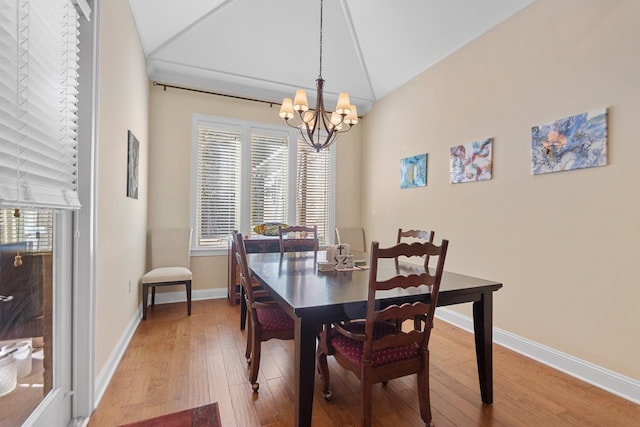 dining room featuring an inviting chandelier, lofted ceiling, and hardwood / wood-style flooring