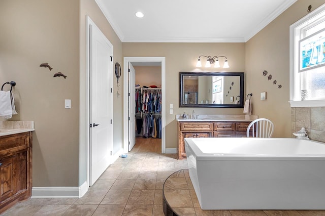 bathroom with vanity, tile patterned floors, crown molding, and a washtub