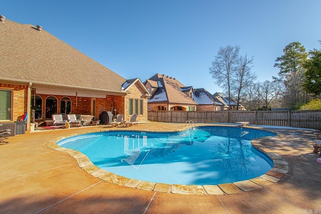 view of pool featuring a diving board and a patio area