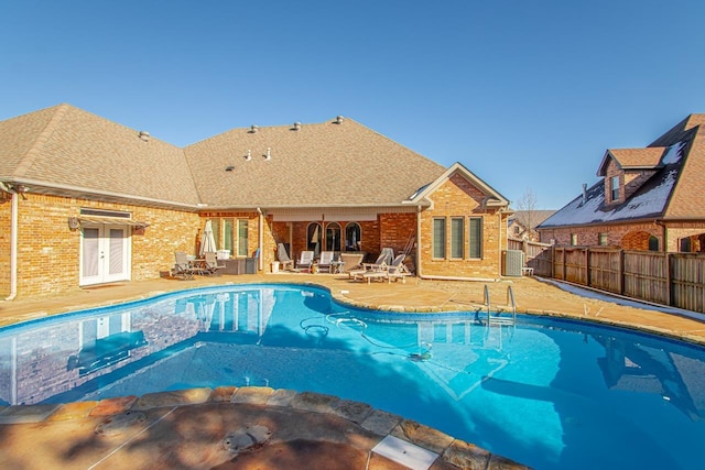 view of swimming pool with central air condition unit, french doors, and a patio