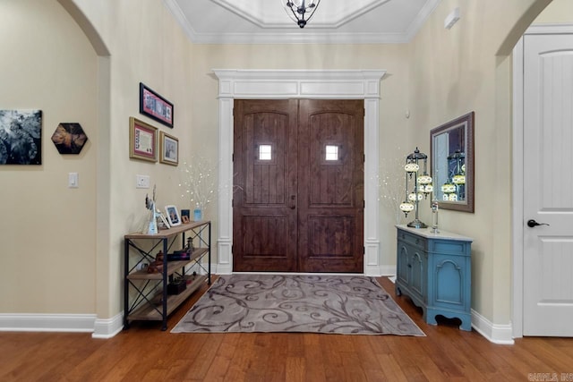 foyer featuring wood-type flooring and ornamental molding