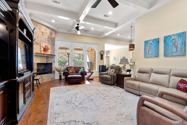 living room featuring ceiling fan, a fireplace, beam ceiling, coffered ceiling, and hardwood / wood-style flooring