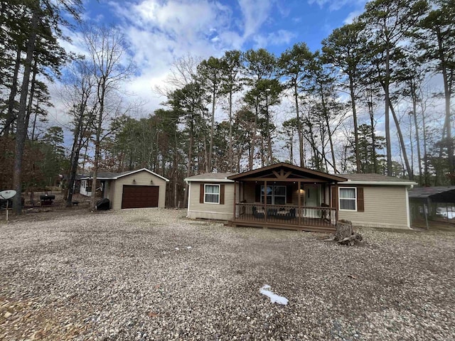 view of front of home featuring covered porch, a garage, and an outdoor structure