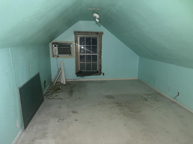 additional living space featuring an AC wall unit and lofted ceiling