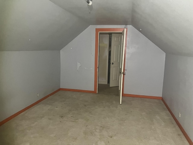 bonus room featuring lofted ceiling and light colored carpet