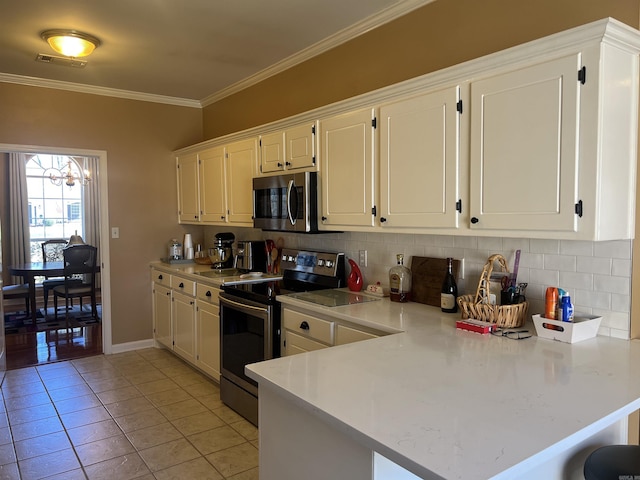 kitchen with backsplash, kitchen peninsula, light tile patterned flooring, appliances with stainless steel finishes, and white cabinets