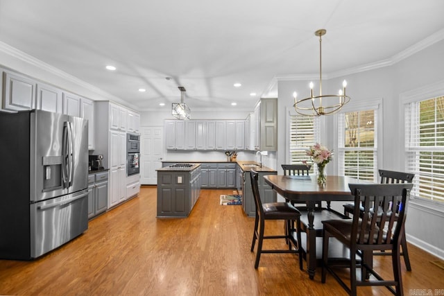 kitchen with stainless steel refrigerator with ice dispenser, sink, crown molding, gray cabinets, and a kitchen island