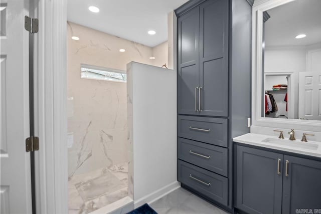 bathroom with tiled shower and vanity