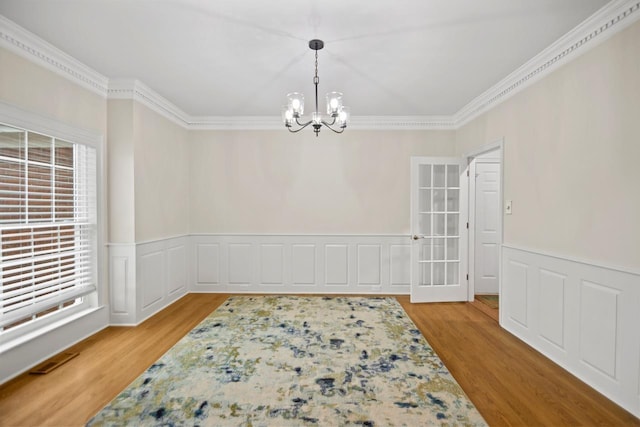 spare room with ornamental molding, a chandelier, and light hardwood / wood-style floors