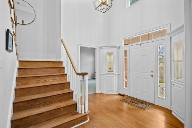 entryway with a towering ceiling, plenty of natural light, and light hardwood / wood-style floors