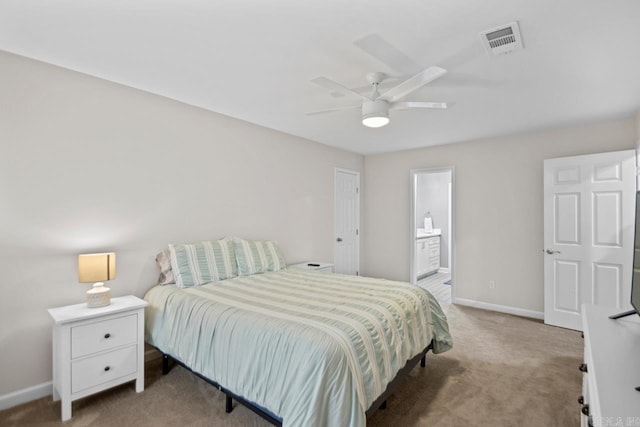 carpeted bedroom with ensuite bath and ceiling fan