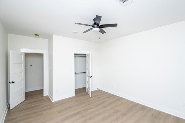 unfurnished bedroom featuring ceiling fan, a closet, and light hardwood / wood-style flooring