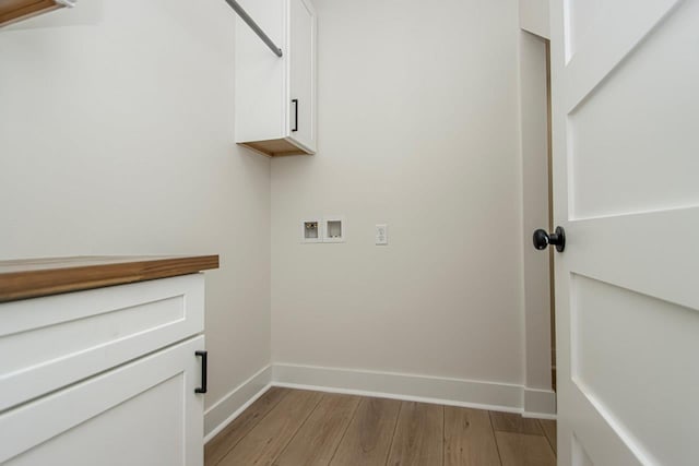 washroom featuring cabinets, hookup for a washing machine, and light wood-type flooring