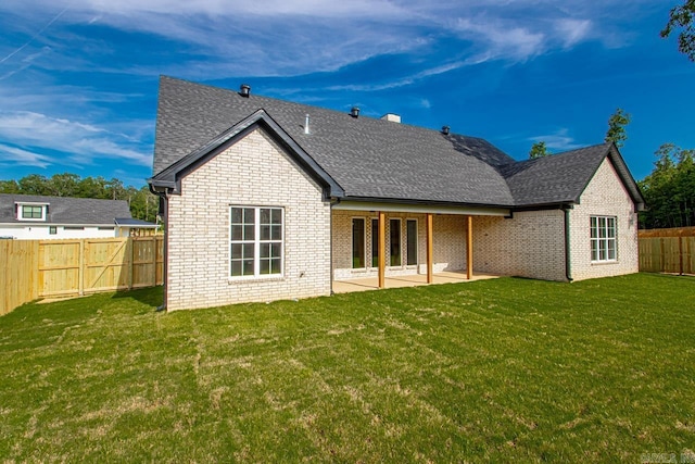 rear view of property featuring a patio and a yard