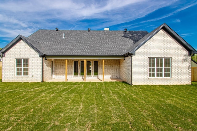 rear view of house with a lawn and a patio