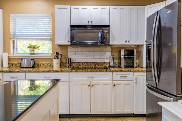 kitchen with white cabinetry, dark stone countertops, and black appliances