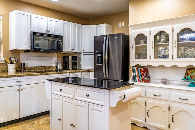 kitchen with white cabinetry, tasteful backsplash, a kitchen island, and black appliances