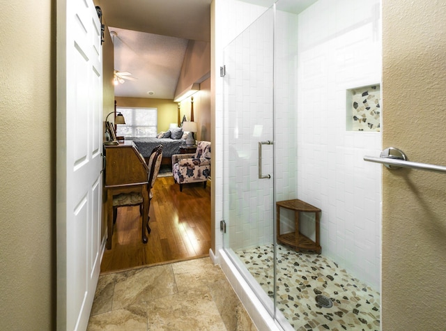 bathroom featuring ceiling fan, lofted ceiling, and a shower with shower door