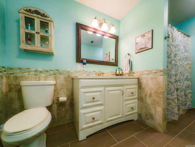 bathroom with tile patterned flooring, vanity, a shower with curtain, tile walls, and toilet