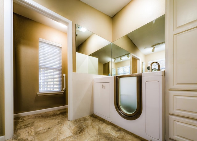 bathroom featuring rail lighting and plenty of natural light